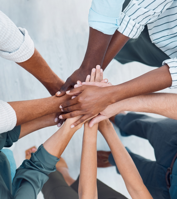 diverse employees putting hands in team situation